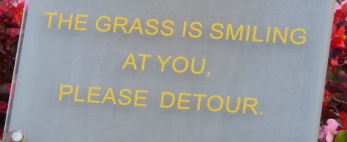 Sign saying 'The grass is smiling at you'